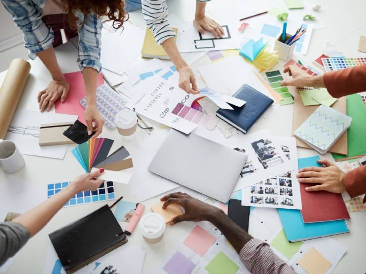 A group of team members huddled around design plans near North Miami Beach, Florida (FL)